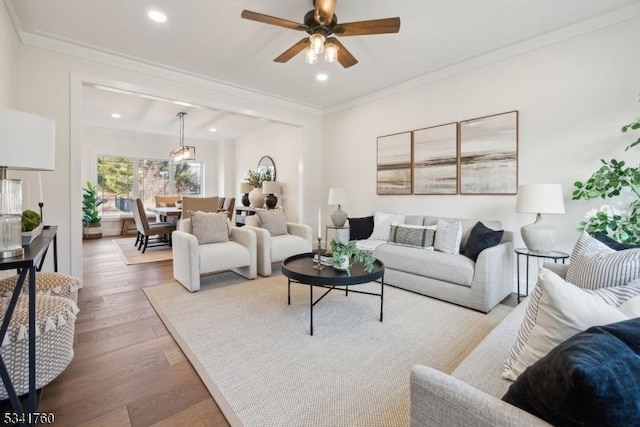 living room featuring ceiling fan, ornamental molding, wood finished floors, and recessed lighting