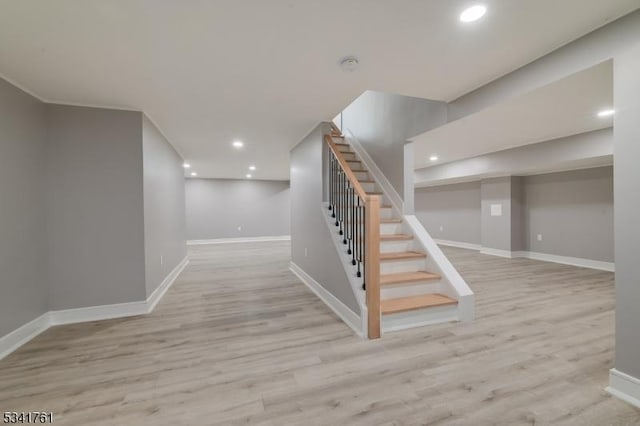 finished below grade area with stairway, recessed lighting, wood finished floors, and baseboards