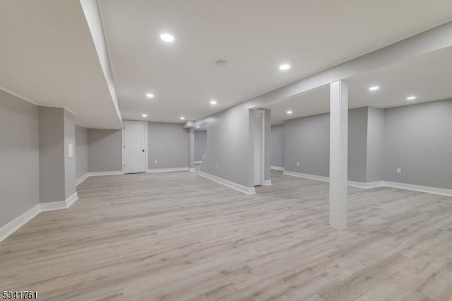 finished below grade area with light wood-style floors, baseboards, and recessed lighting