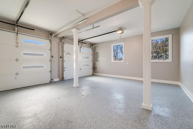 garage featuring electric panel, baseboards, and a garage door opener