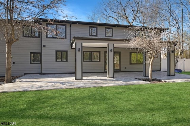 back of property with a patio area, a lawn, and fence