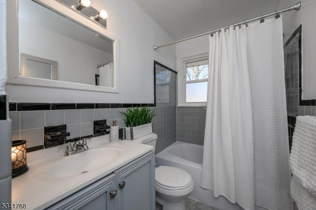 bathroom with toilet, shower / tub combo, vanity, and tile walls