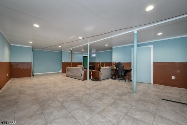 finished basement featuring a wainscoted wall, crown molding, and recessed lighting