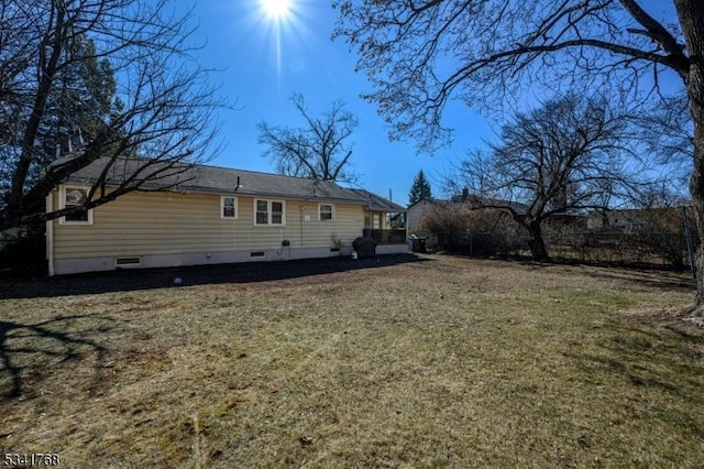 rear view of house with crawl space and a yard