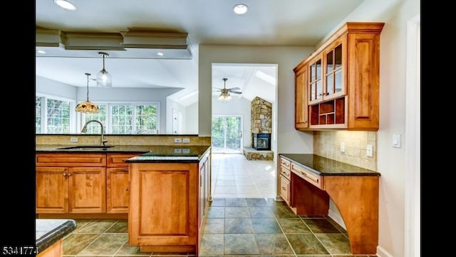 kitchen with decorative backsplash, brown cabinetry, a wealth of natural light, and a sink