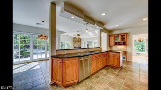 kitchen featuring stainless steel dishwasher, backsplash, a wealth of natural light, and a sink