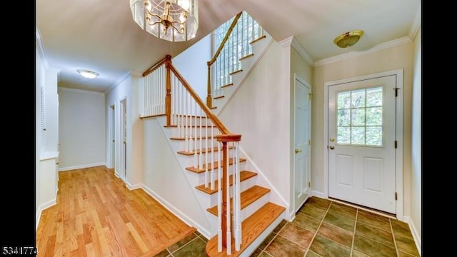 foyer entrance featuring stairway, crown molding, and baseboards