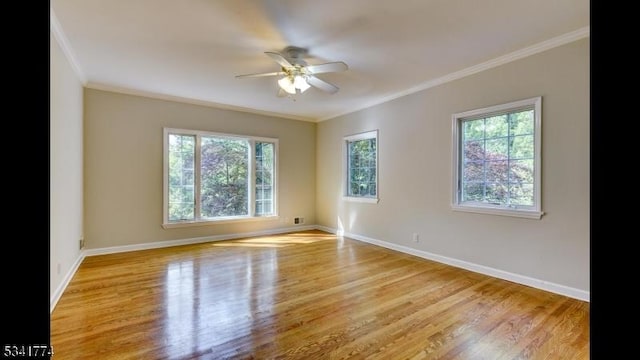 empty room with ceiling fan, baseboards, light wood finished floors, and ornamental molding