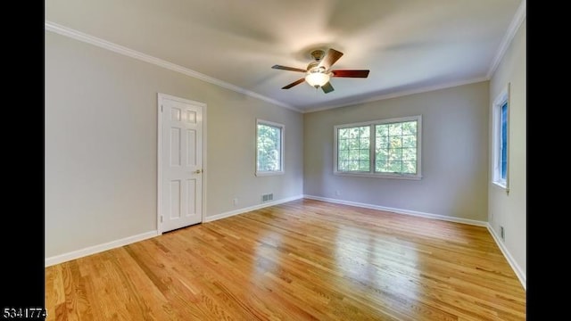 unfurnished room with visible vents, crown molding, light wood-type flooring, and baseboards