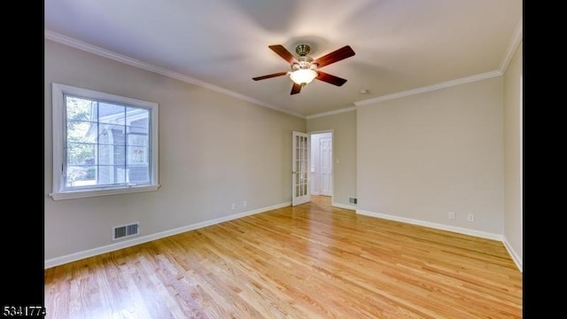 empty room with crown molding, baseboards, visible vents, and light wood finished floors