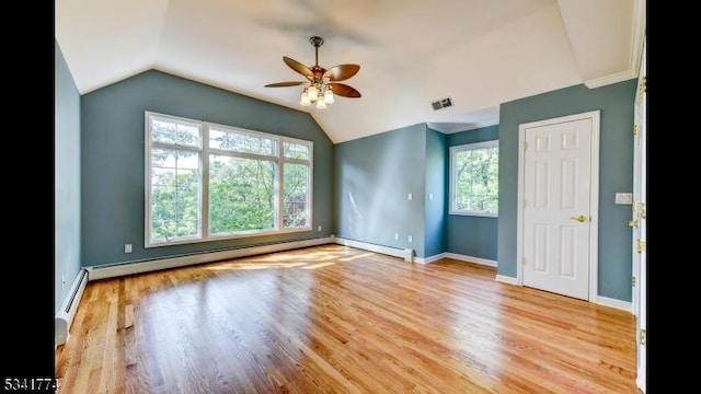 spare room with baseboards, lofted ceiling, baseboard heating, and light wood finished floors