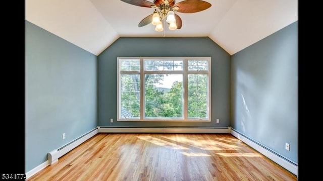 unfurnished room featuring lofted ceiling, baseboard heating, wood finished floors, and a ceiling fan