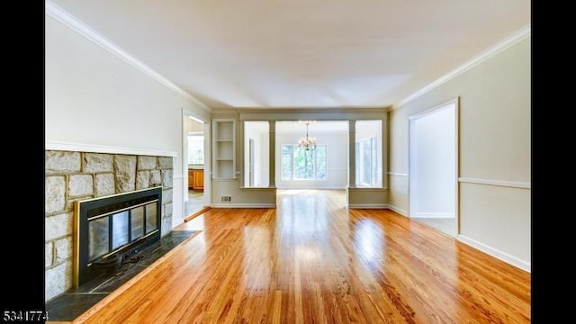 unfurnished living room featuring a stone fireplace, wood finished floors, baseboards, and ornamental molding