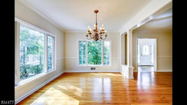 unfurnished dining area featuring decorative columns, visible vents, ornamental molding, and light wood finished floors