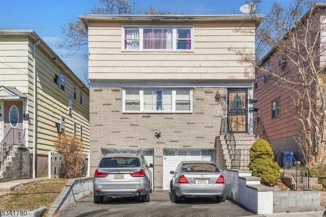 view of front of property featuring brick siding, concrete driveway, and a garage