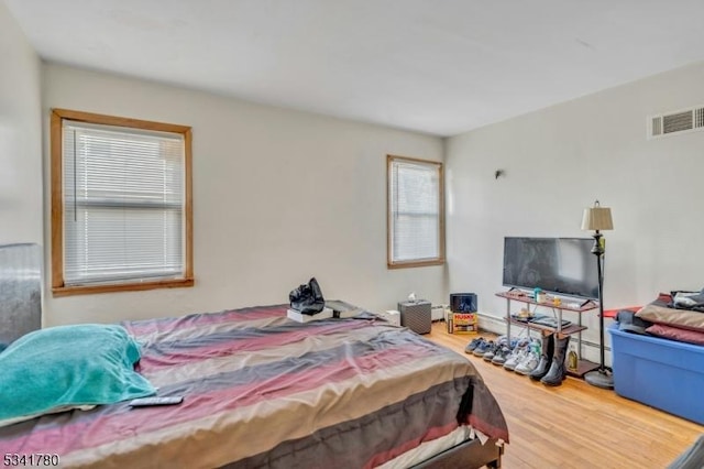 bedroom with visible vents and wood finished floors