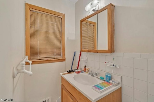 bathroom featuring vanity and tile walls