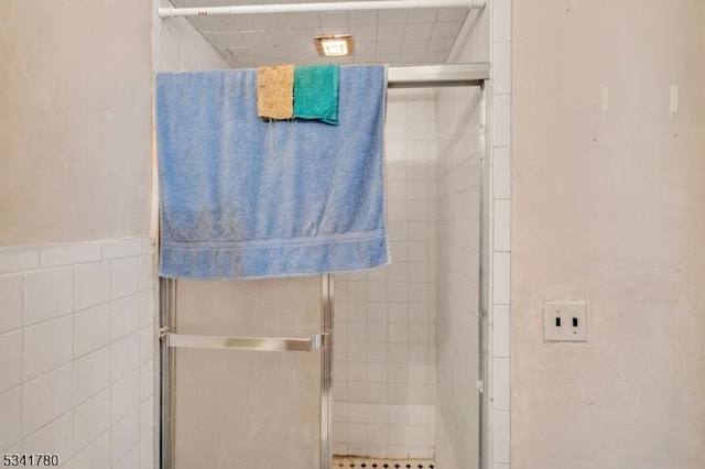 bathroom with tile walls and a stall shower