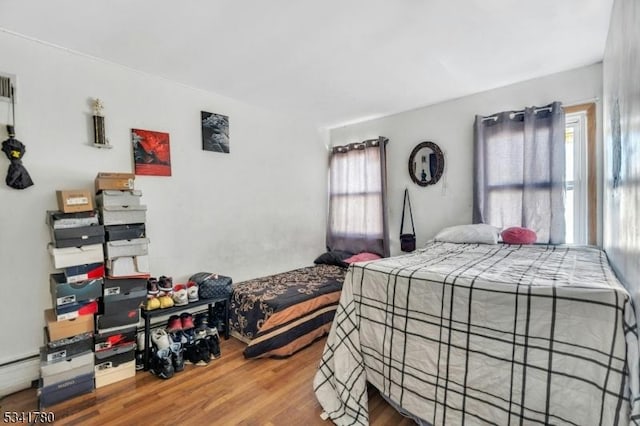 bedroom featuring a baseboard radiator and wood finished floors