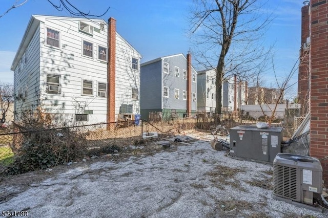 view of side of home with central AC and fence