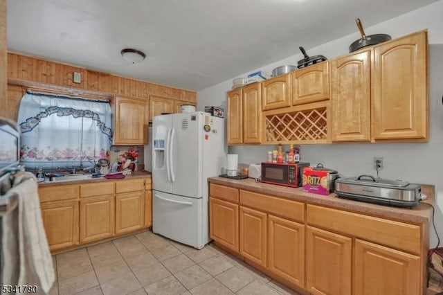 kitchen featuring light countertops, light tile patterned floors, white refrigerator with ice dispenser, and black microwave