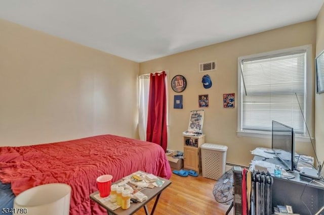 bedroom featuring visible vents and light wood-style flooring