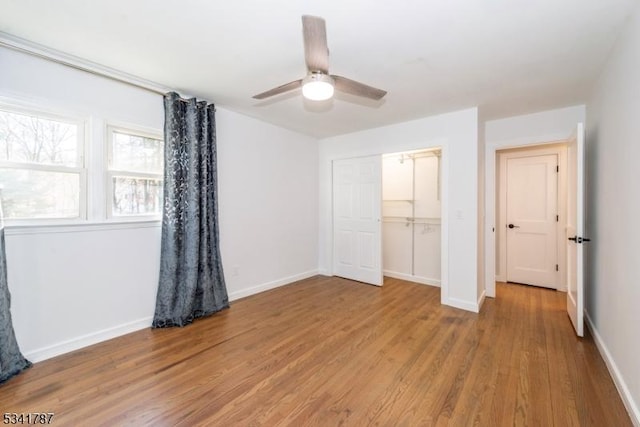 unfurnished bedroom with light wood-type flooring, a closet, baseboards, and a ceiling fan