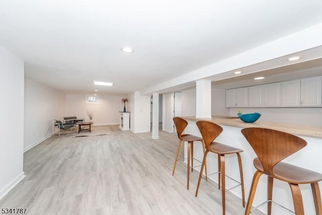 bar featuring light wood finished floors, baseboards, and recessed lighting