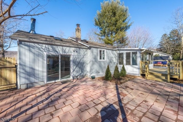 back of house with a patio area, fence, a chimney, and a wooden deck