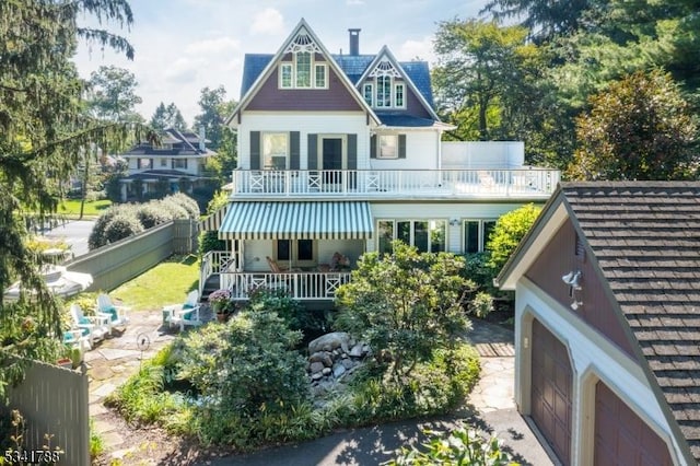 back of house featuring a balcony and fence