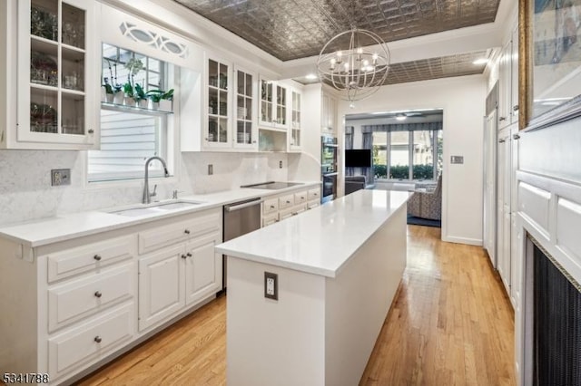 kitchen featuring a sink, white cabinetry, backsplash, a center island, and an ornate ceiling