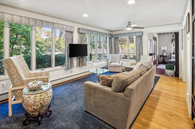 sunroom with a baseboard radiator and a ceiling fan