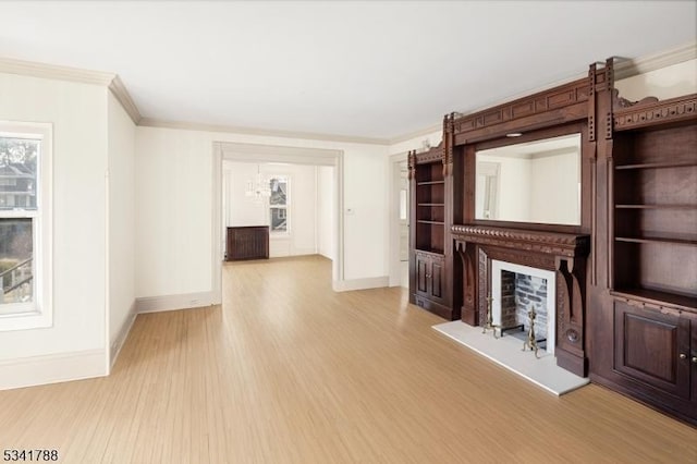 unfurnished living room featuring baseboards, light wood-style floors, a fireplace, and crown molding