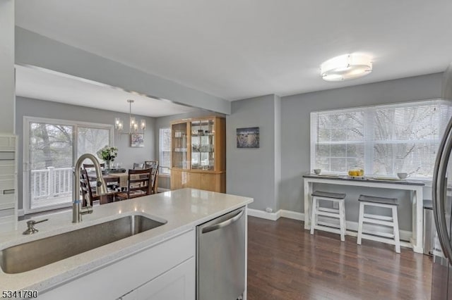 kitchen with a notable chandelier, a sink, white cabinets, dishwasher, and dark wood-style flooring