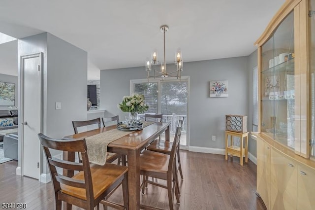 dining area featuring dark wood-style floors, a chandelier, and baseboards