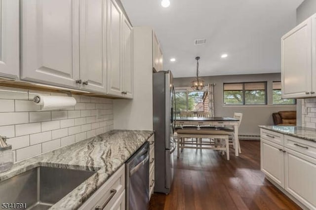 kitchen featuring visible vents, light stone counters, dark wood-style floors, white cabinetry, and stainless steel appliances