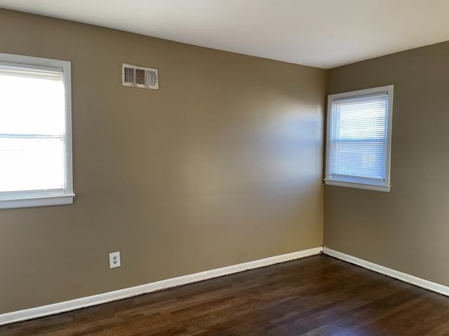 spare room featuring a wealth of natural light, visible vents, and baseboards