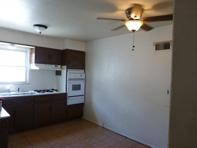 kitchen featuring white appliances, visible vents, under cabinet range hood, a sink, and a warming drawer