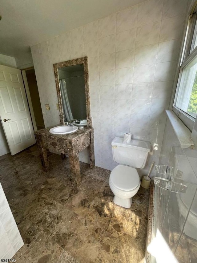 bathroom featuring tile walls, toilet, and vanity