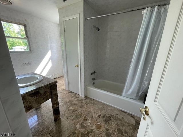 bathroom with shower / bath combo, tile walls, and vanity