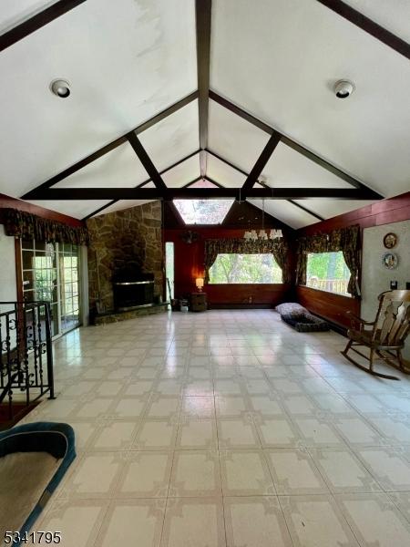 unfurnished living room with lofted ceiling with beams and a fireplace