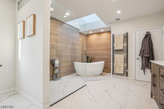 bathroom featuring visible vents, a soaking tub, marble finish floor, vanity, and recessed lighting