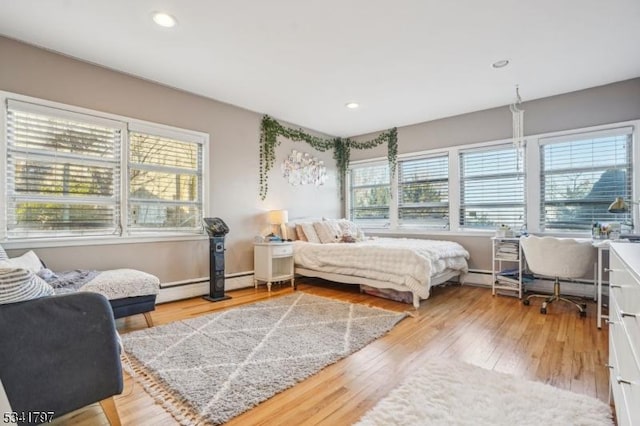 bedroom featuring recessed lighting, baseboard heating, and wood finished floors