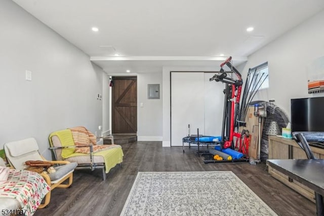 interior space with electric panel, baseboards, wood finished floors, and recessed lighting