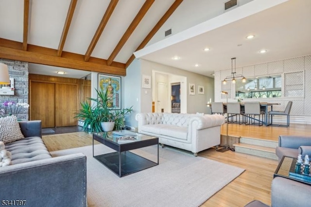 living area with recessed lighting, visible vents, lofted ceiling with beams, and wood finished floors