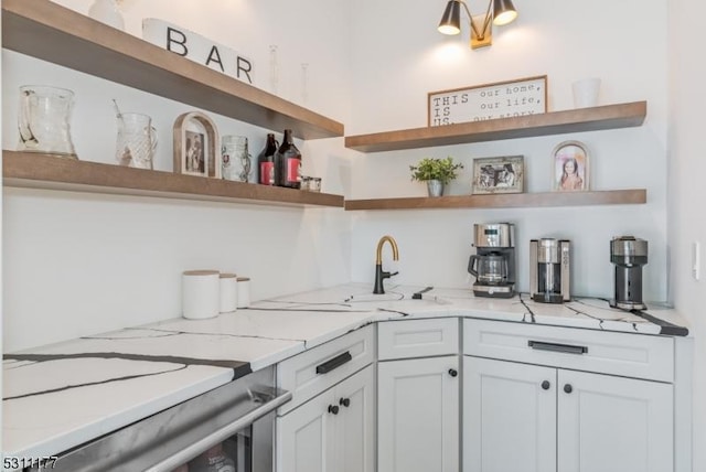 kitchen featuring light stone countertops, white cabinetry, and open shelves