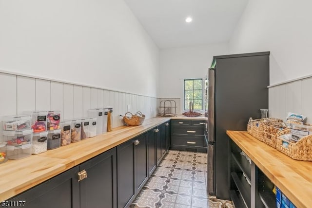 kitchen with recessed lighting, wainscoting, wood counters, and light floors