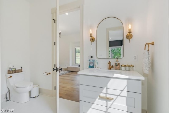 bathroom with baseboards, vanity, and toilet