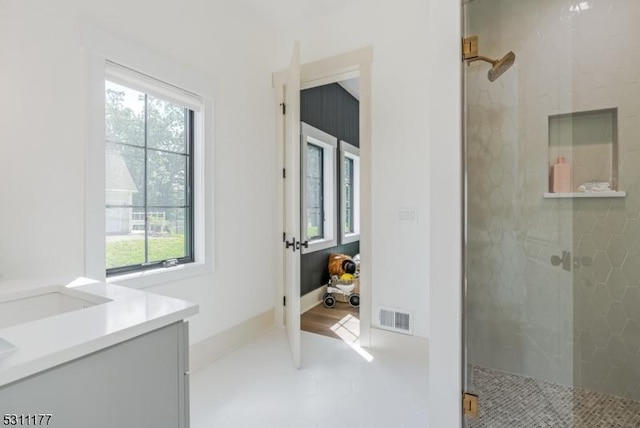 bathroom with a wealth of natural light, a shower stall, and visible vents