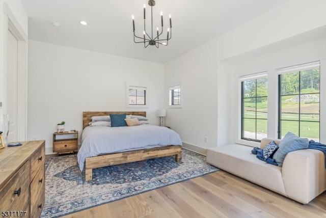 bedroom with recessed lighting, baseboards, a notable chandelier, and light wood finished floors